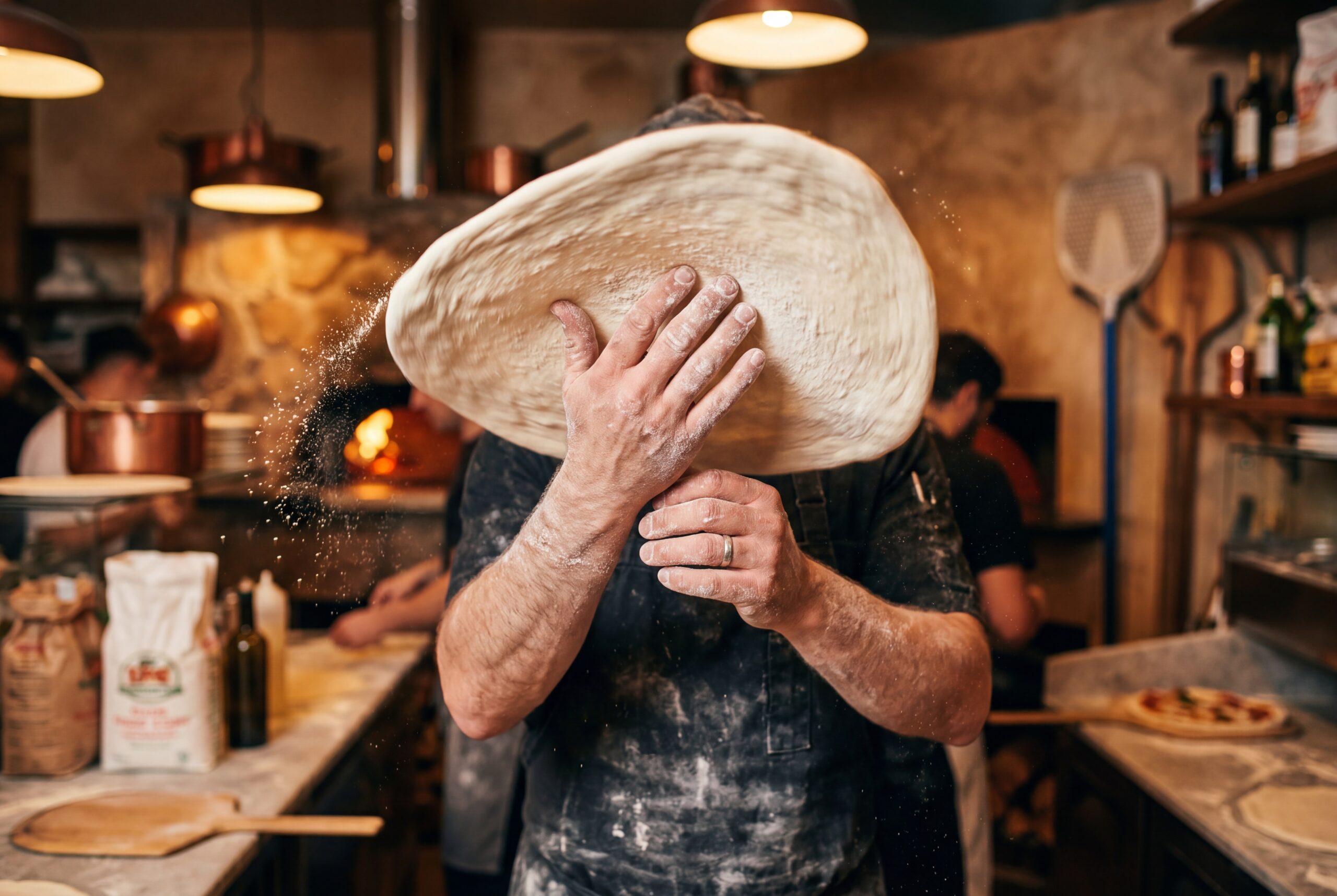 Chef stretching pizza dough by hand